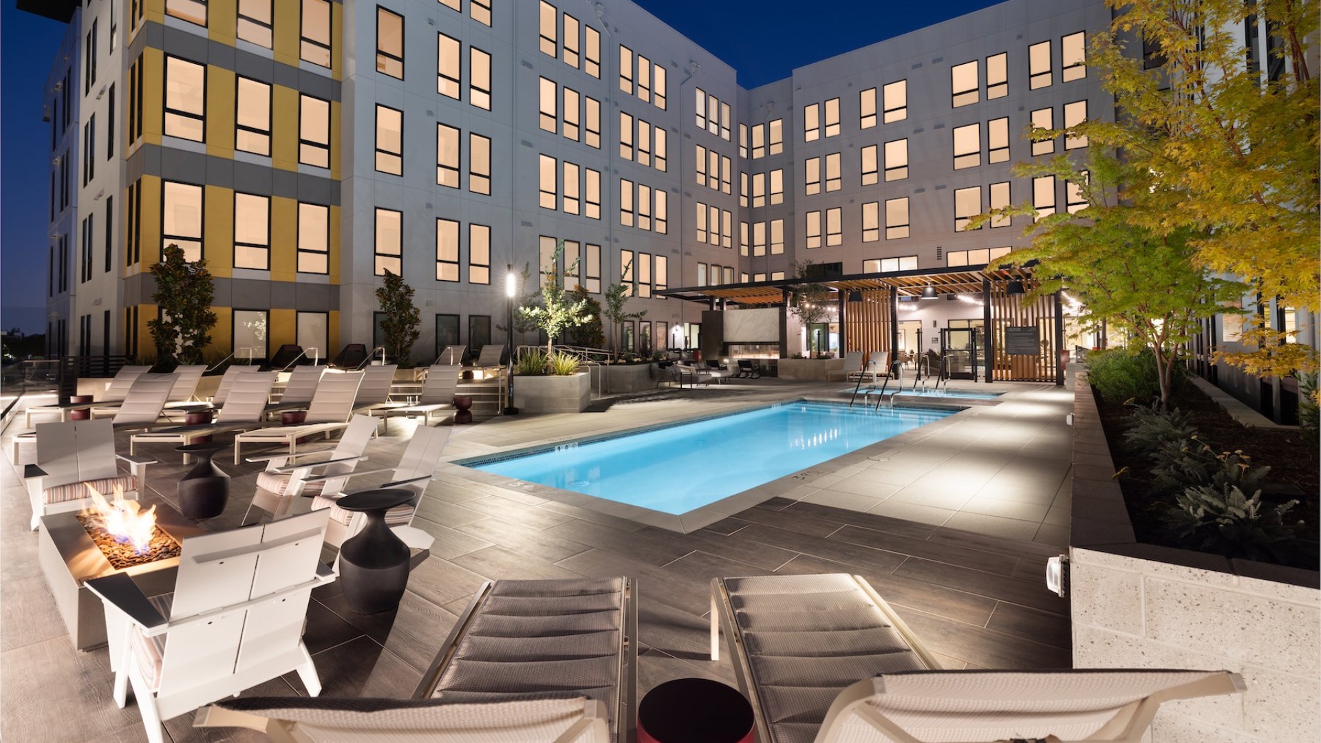 a swimming pool with lounge chairs and a fireplace
