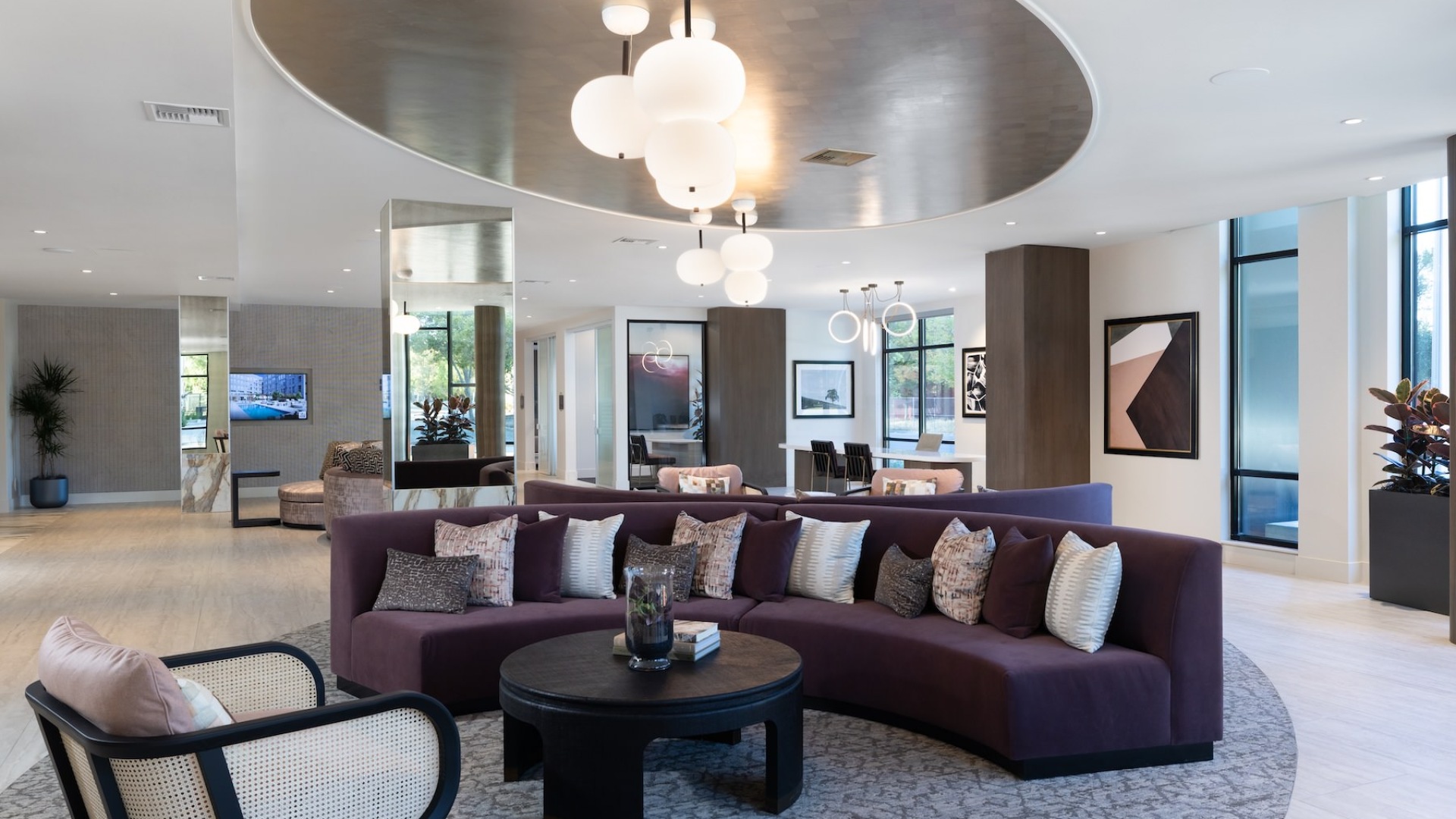 a lounge area with a large couch, tables and chairs